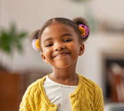 Smiling cute girl with two pony tails looking at camera. 