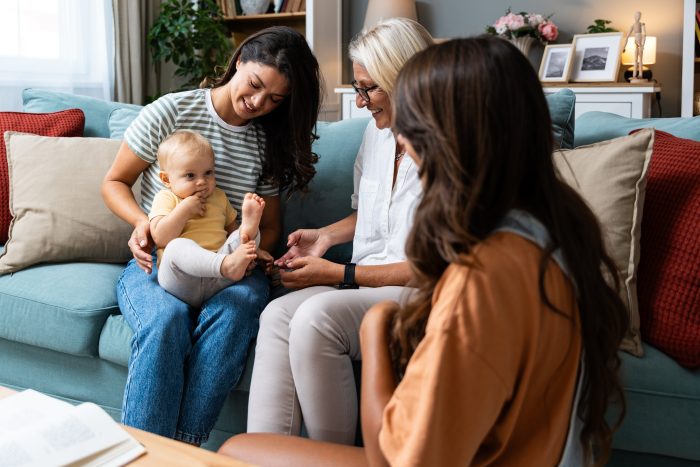 Happy family. Grandmother, mother, aunt and little baby having fun at home. Relatives visiting newborn child.
