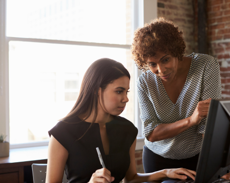 two women staring at a monitor screen