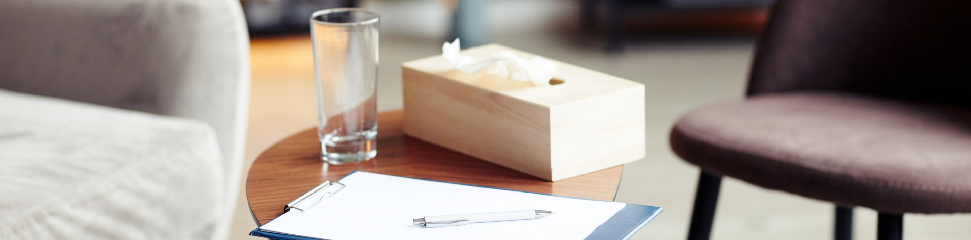 a table with a glass, tissue box and clipboard
