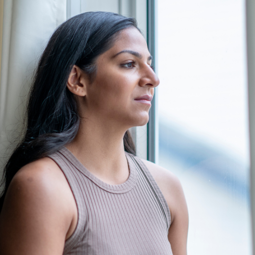 woman looking out window thinking