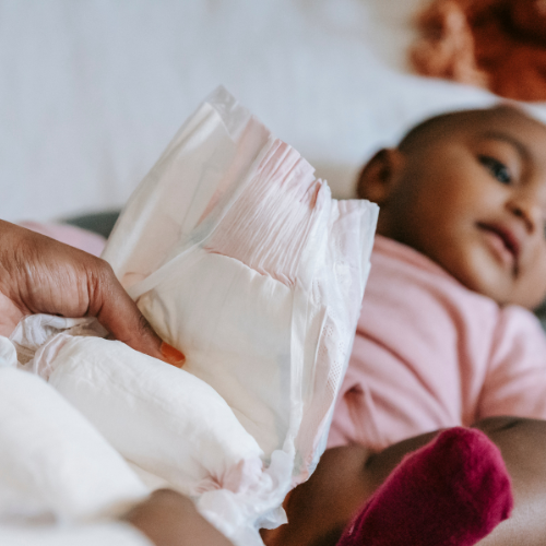 woman changing baby diaper