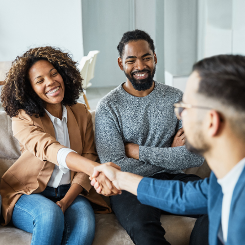 couple shaking hands with business professional