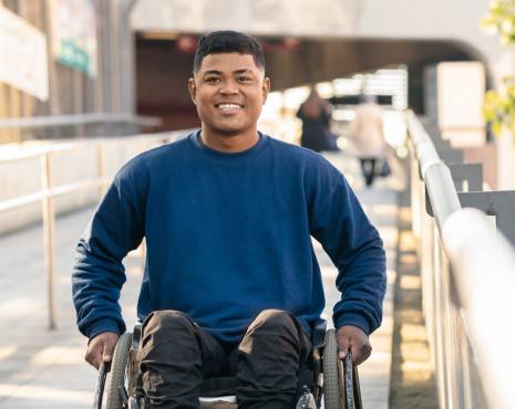 young man outside smiling in a wheelchair