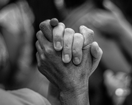 black and white image of two people holding hands