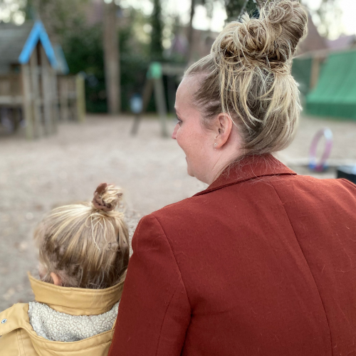 mom and daughter sitting next to each other in playground