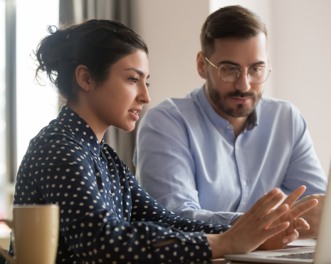woman and man staring at a laptop