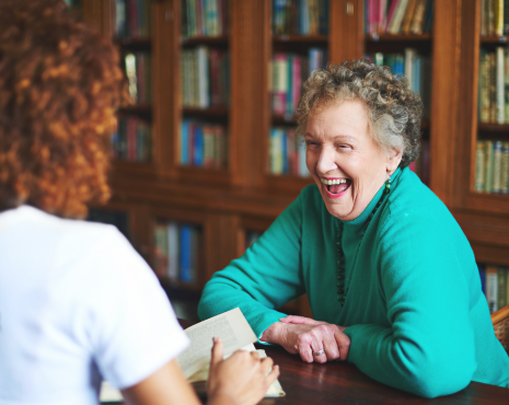 older woman sitting down and laughing with rep