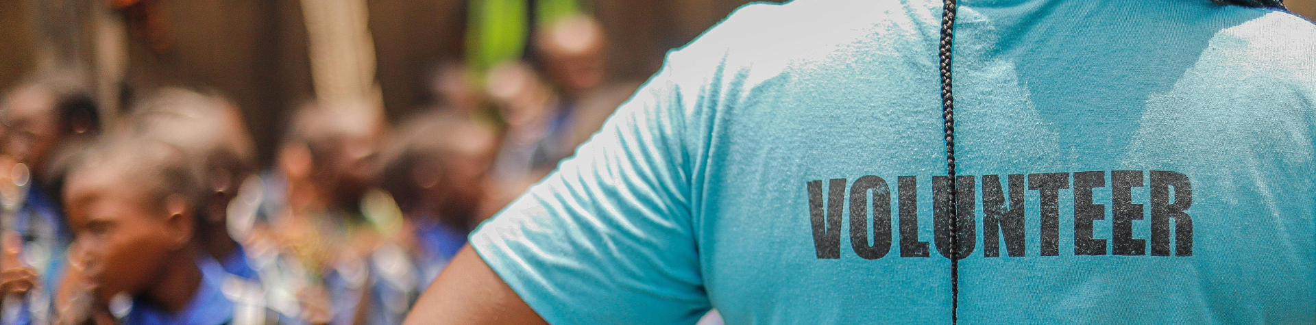 woman standing with her back towards the camera in a volunteer tshirt
