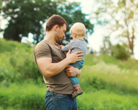 Father With Son Standing In A Park