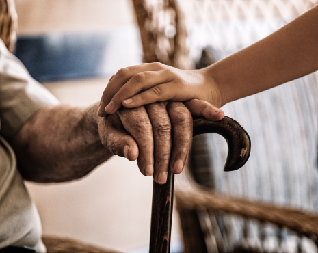 young person putting hand on elderly man