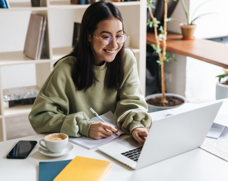 Young Woman With Glasses Smiling Looking At Computer
